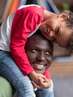 african american father and son spending time together at home